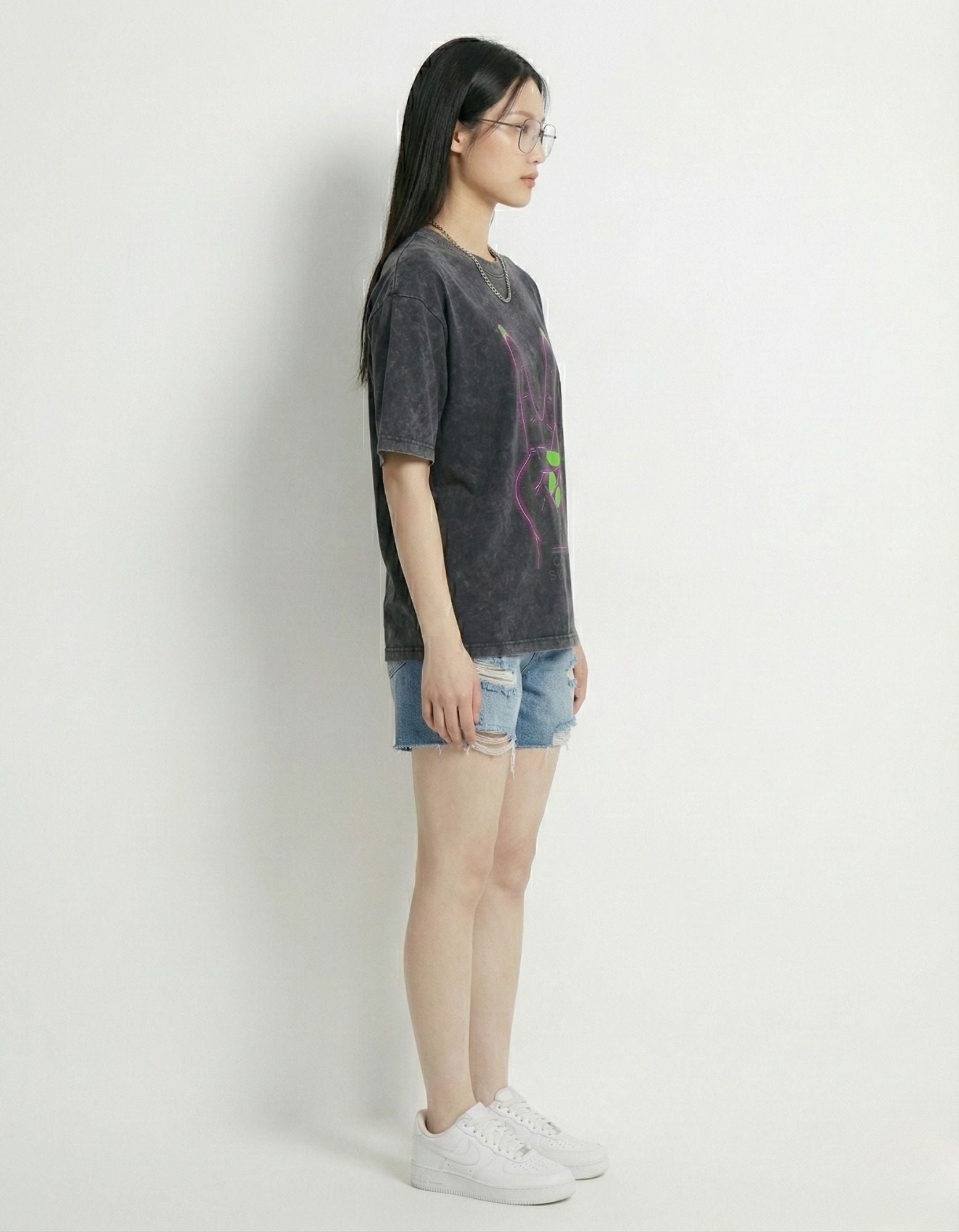 "Side view of a women's oversized acid wash t-shirt demonstrating the drop-shoulder streetwear fit."