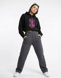 Front view of black oversized hoodie with pink graphic print worn by female model
