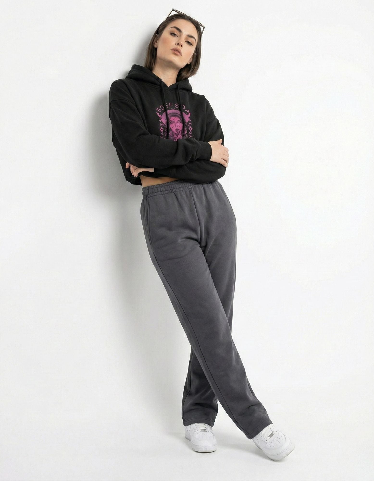Lifestyle front pose of black oversized hoodie with pink graphic design