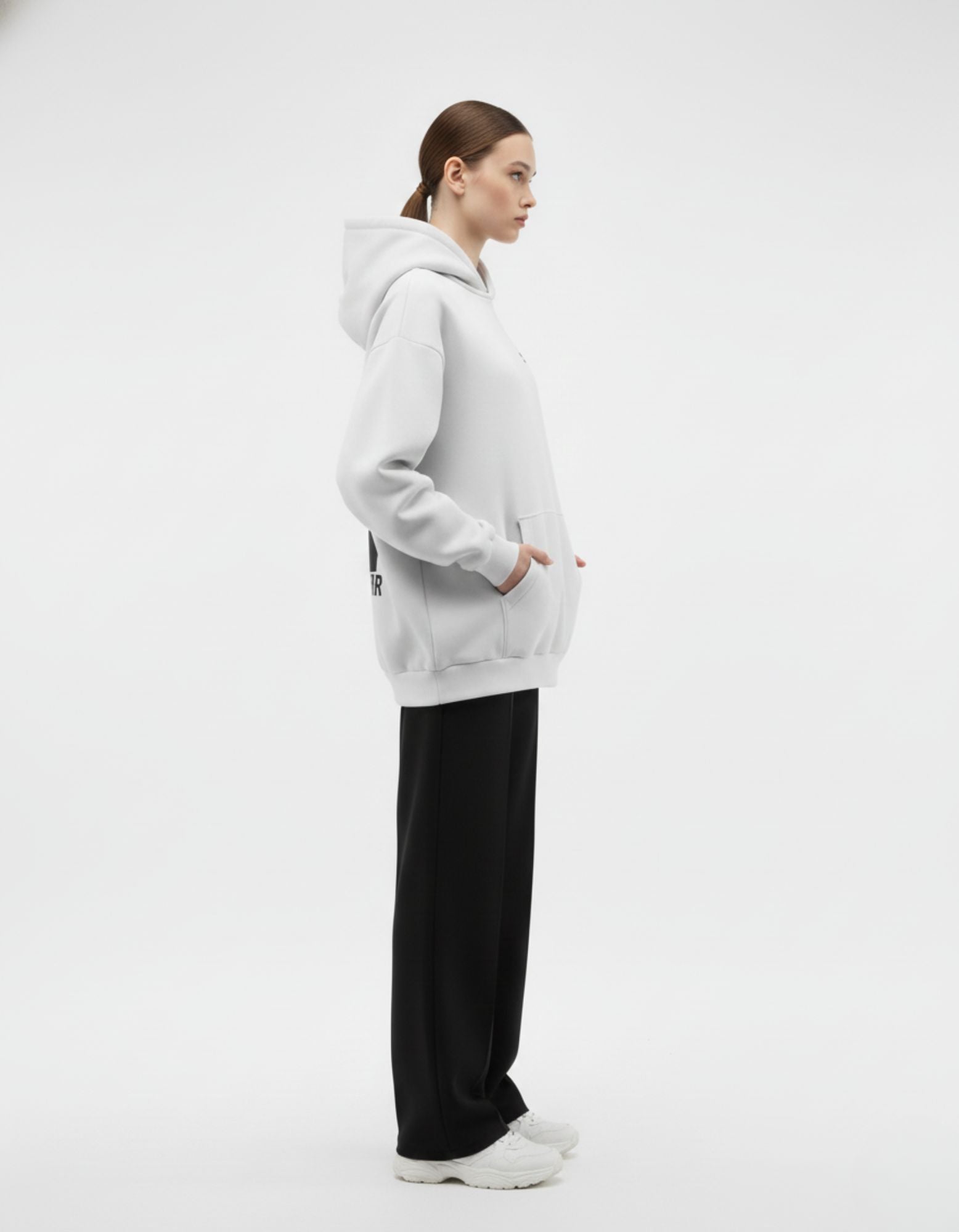Side pose of light grey oversized hoodie showing relaxed oversized fit
