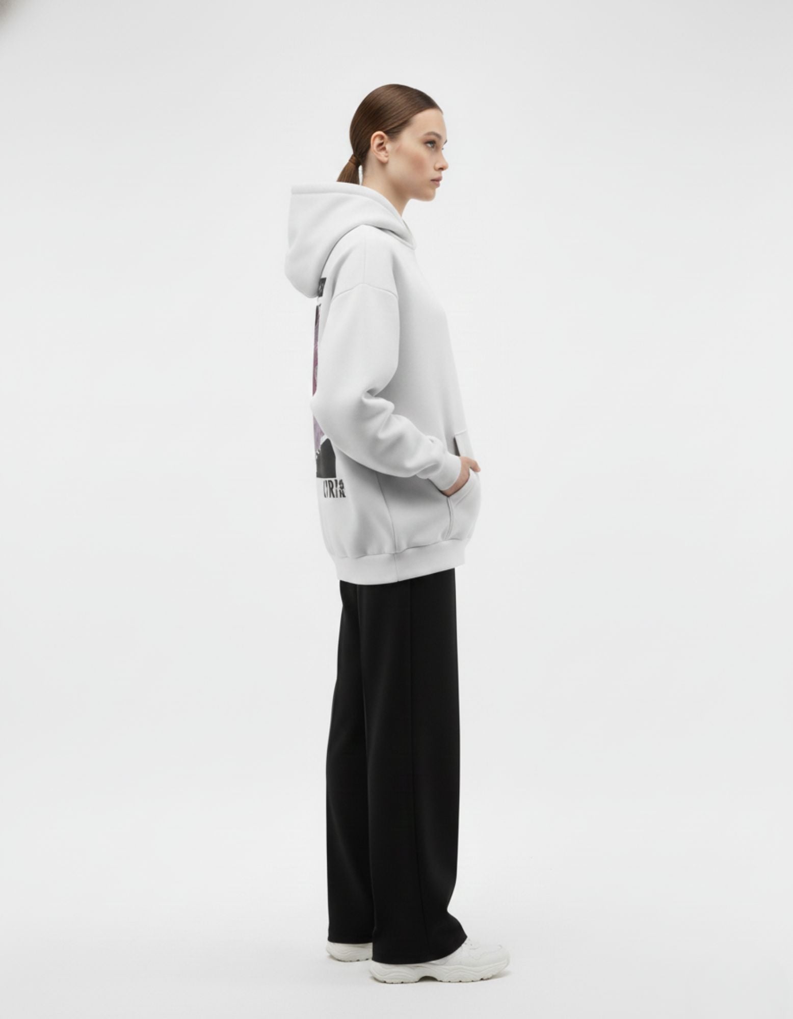 Side profile of light grey oversized hoodie worn by female model
