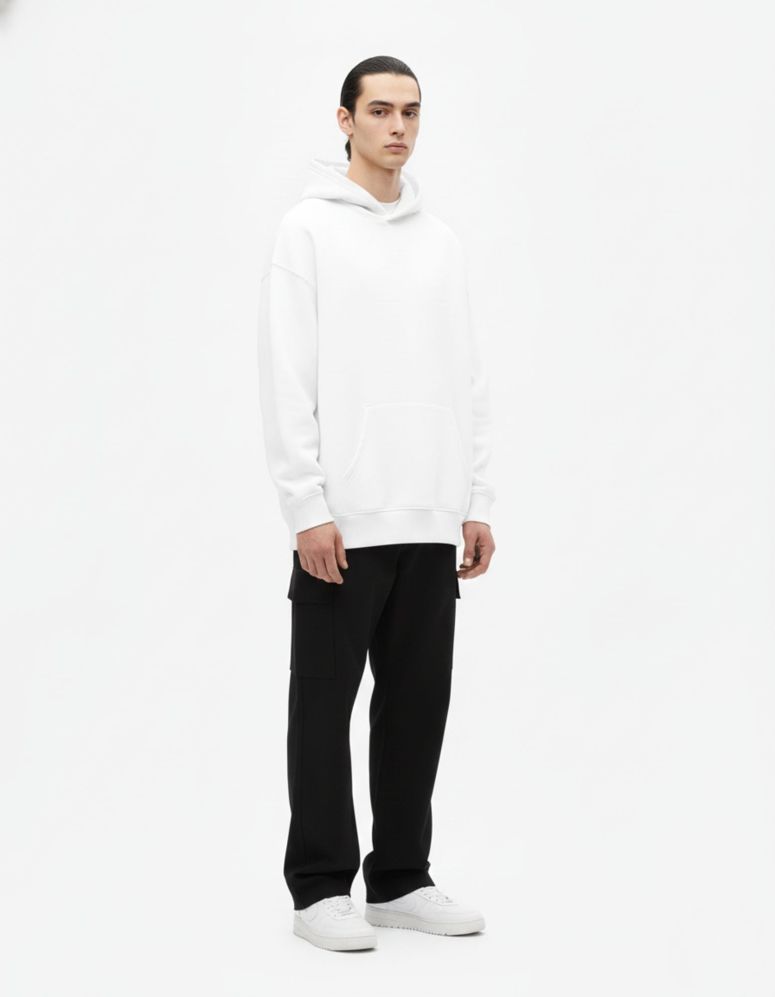 Front angled view of white oversized hoodie worn by male model