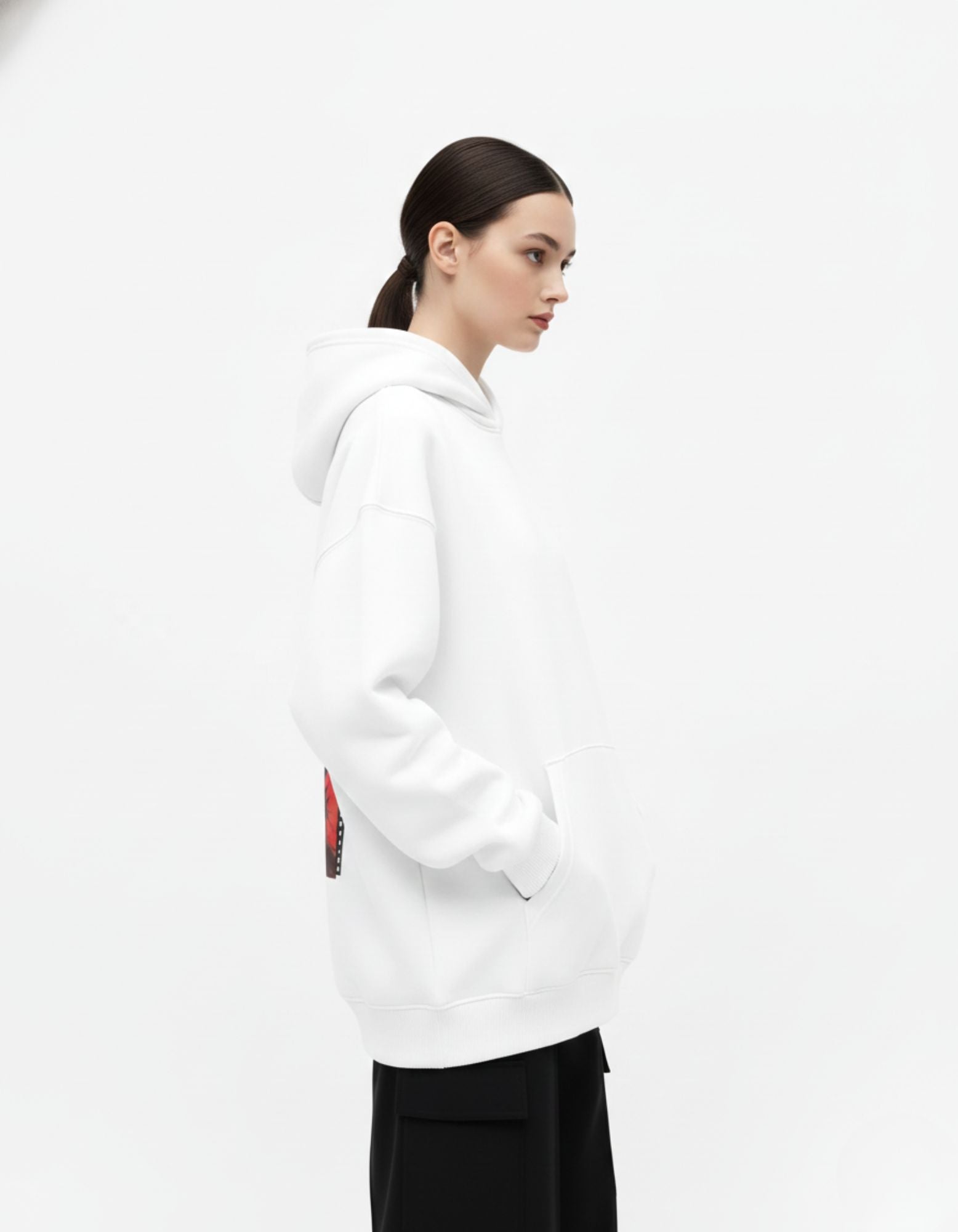 Side view of white oversized hoodie worn by female model
