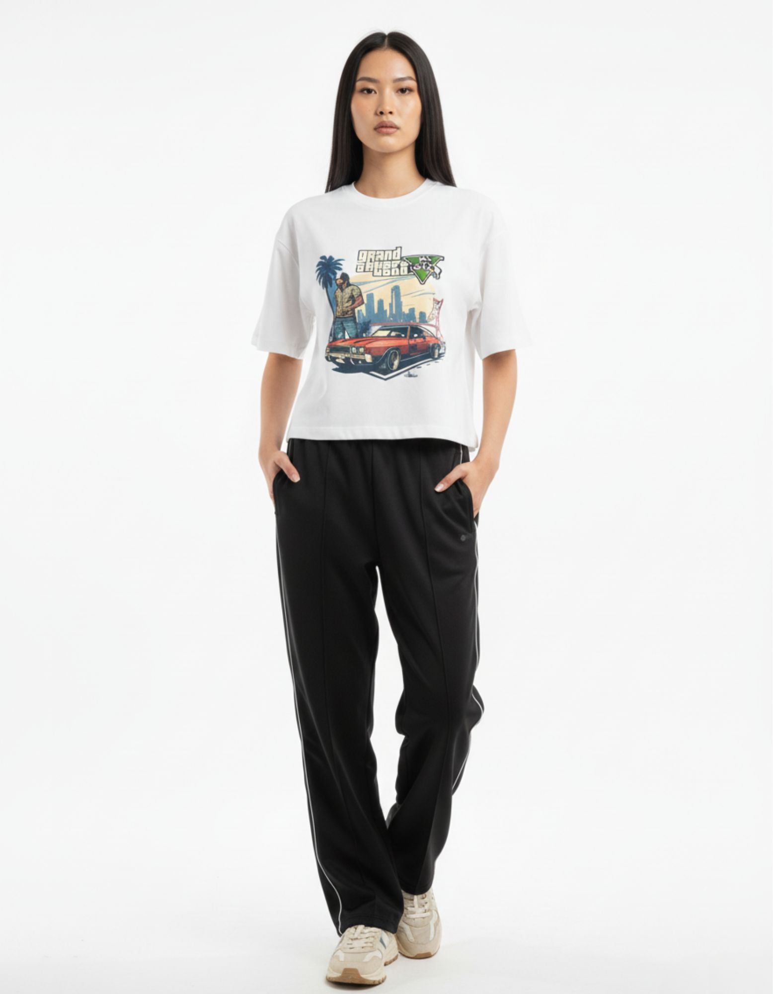 Woman styling white oversized graphic t-shirt with GTA parody print, streetwear fashion India.