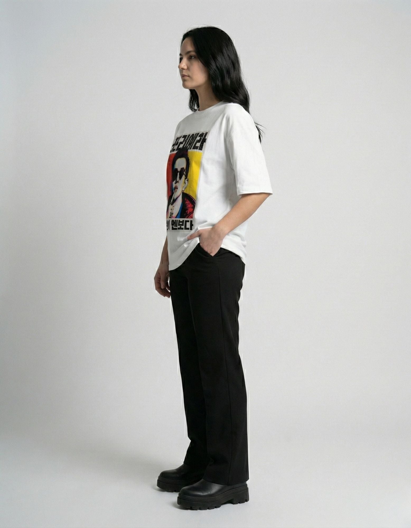 "Side view of female model in a baggy white graphic t-shirt, comfortable streetwear for women."