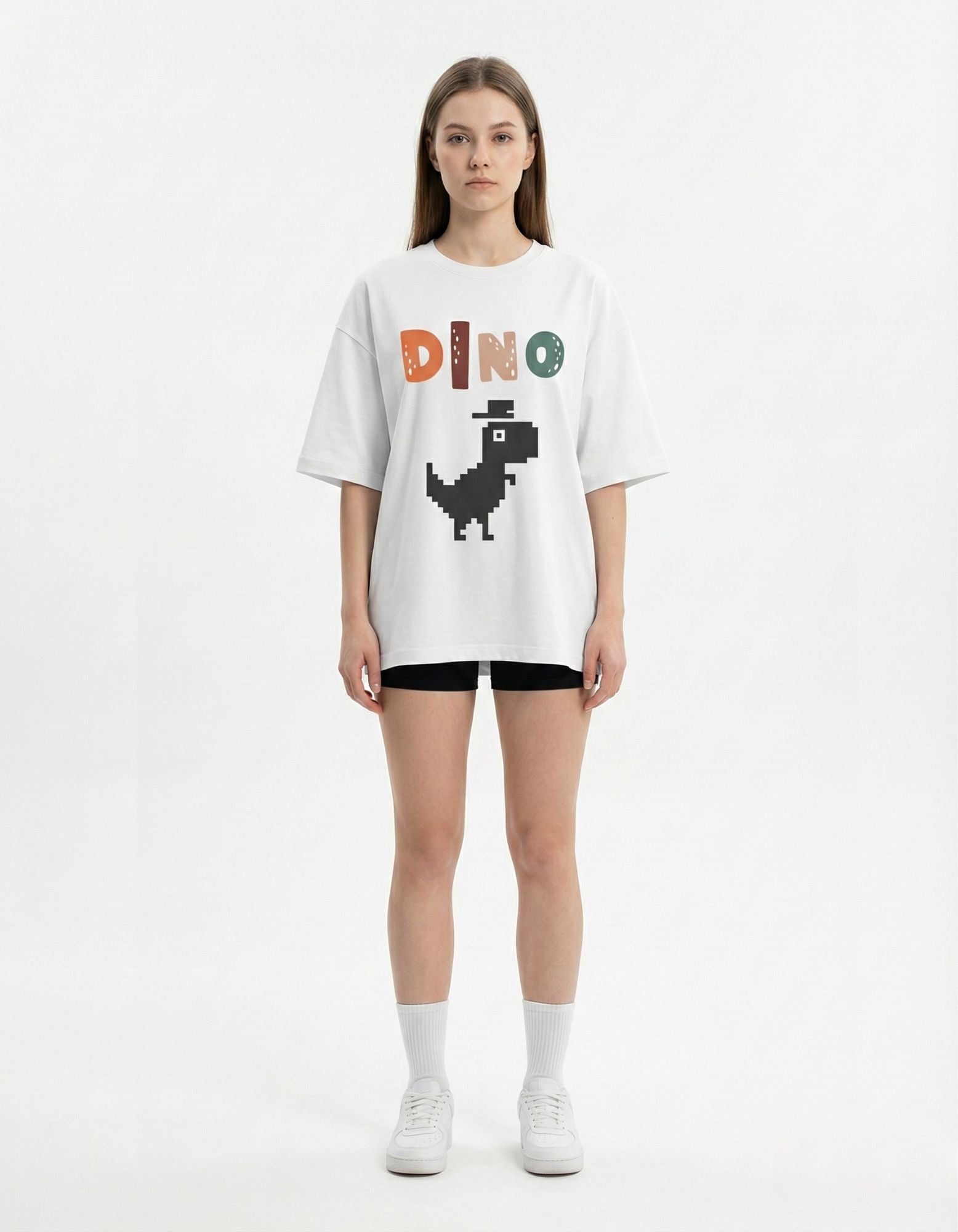 Front view of white oversized t-shirt with pixel art dinosaur graphic, trendy 8-bit streetwear for Indian gamers.