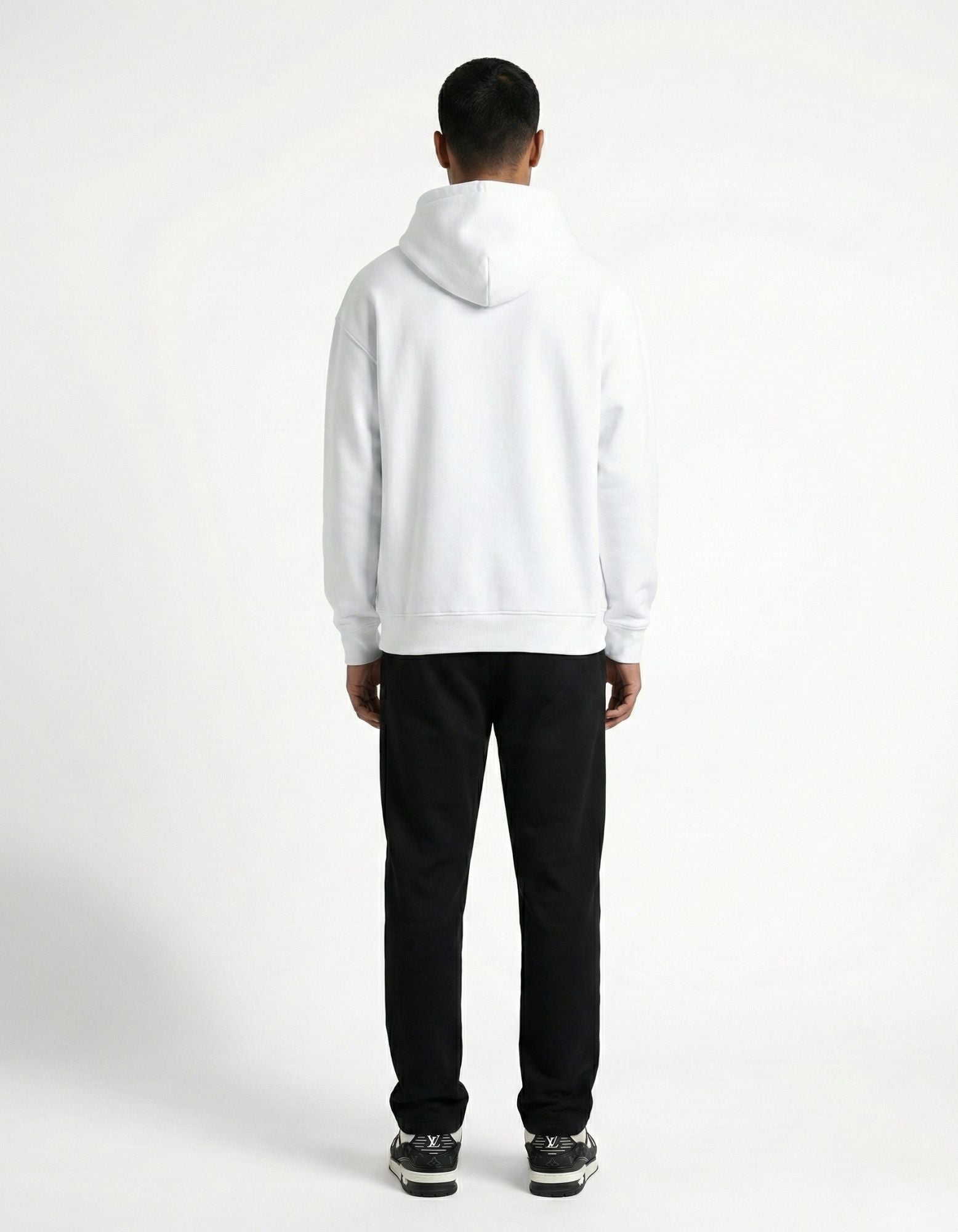 Back view of a male model in a clean white oversized hoodie, showing the premium heavyweight cotton texture.