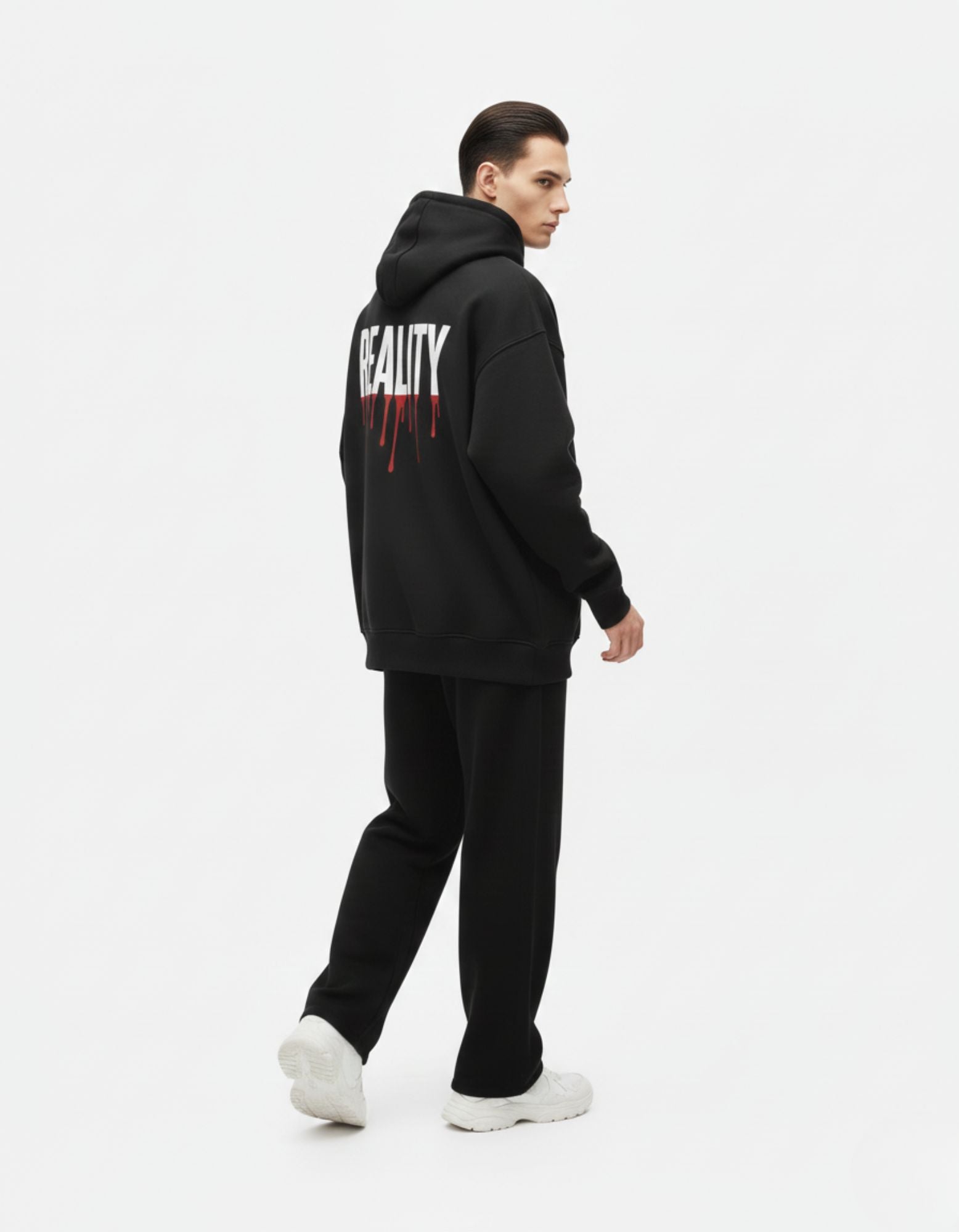 "Side profile of a male model in a GENZs Fashion heavyweight black hoodie showing the relaxed, drop-shoulder oversized fit."