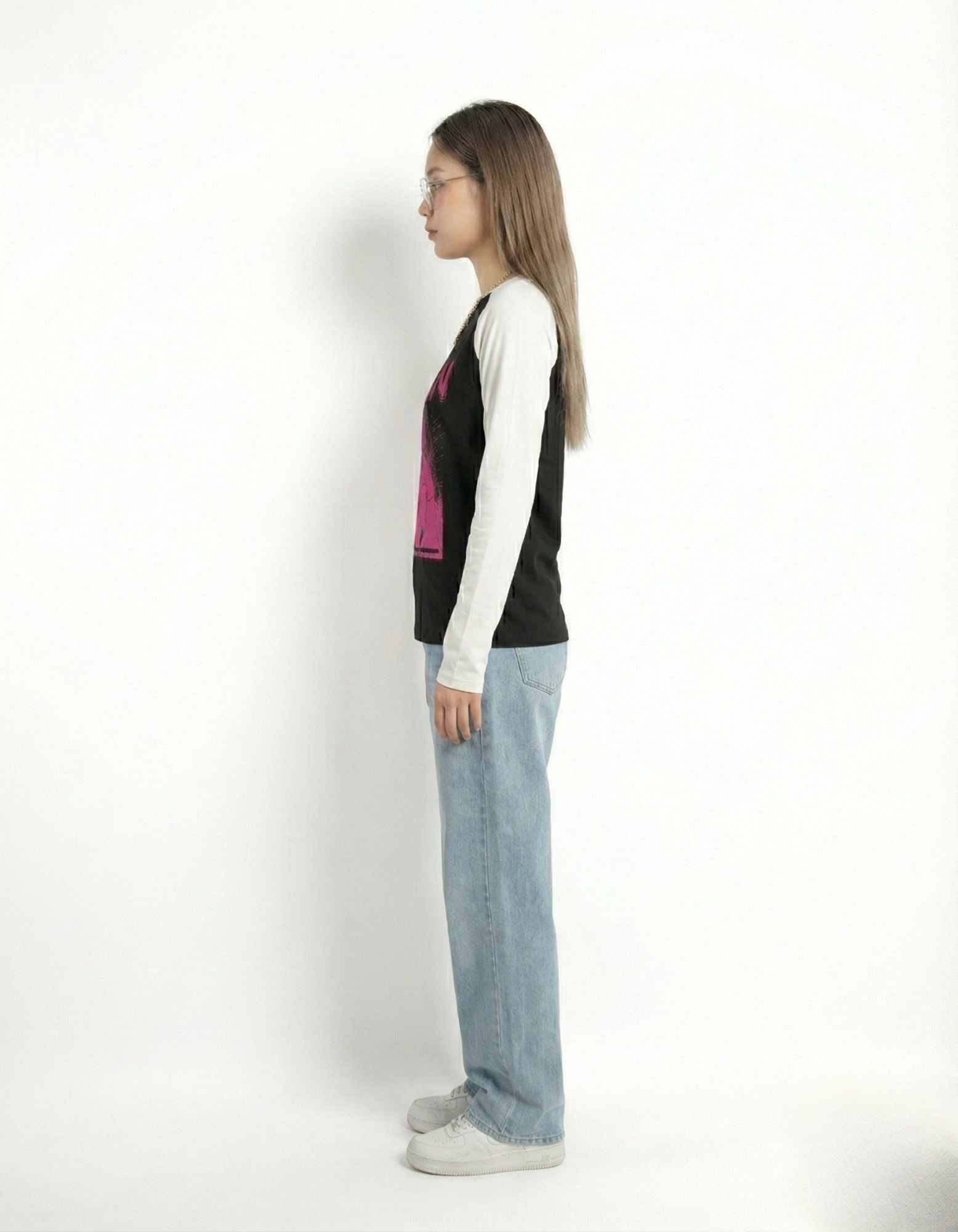 Side profile view of a slim-fit raglan long-sleeve shirt with contrast sleeves and pink graphic design.