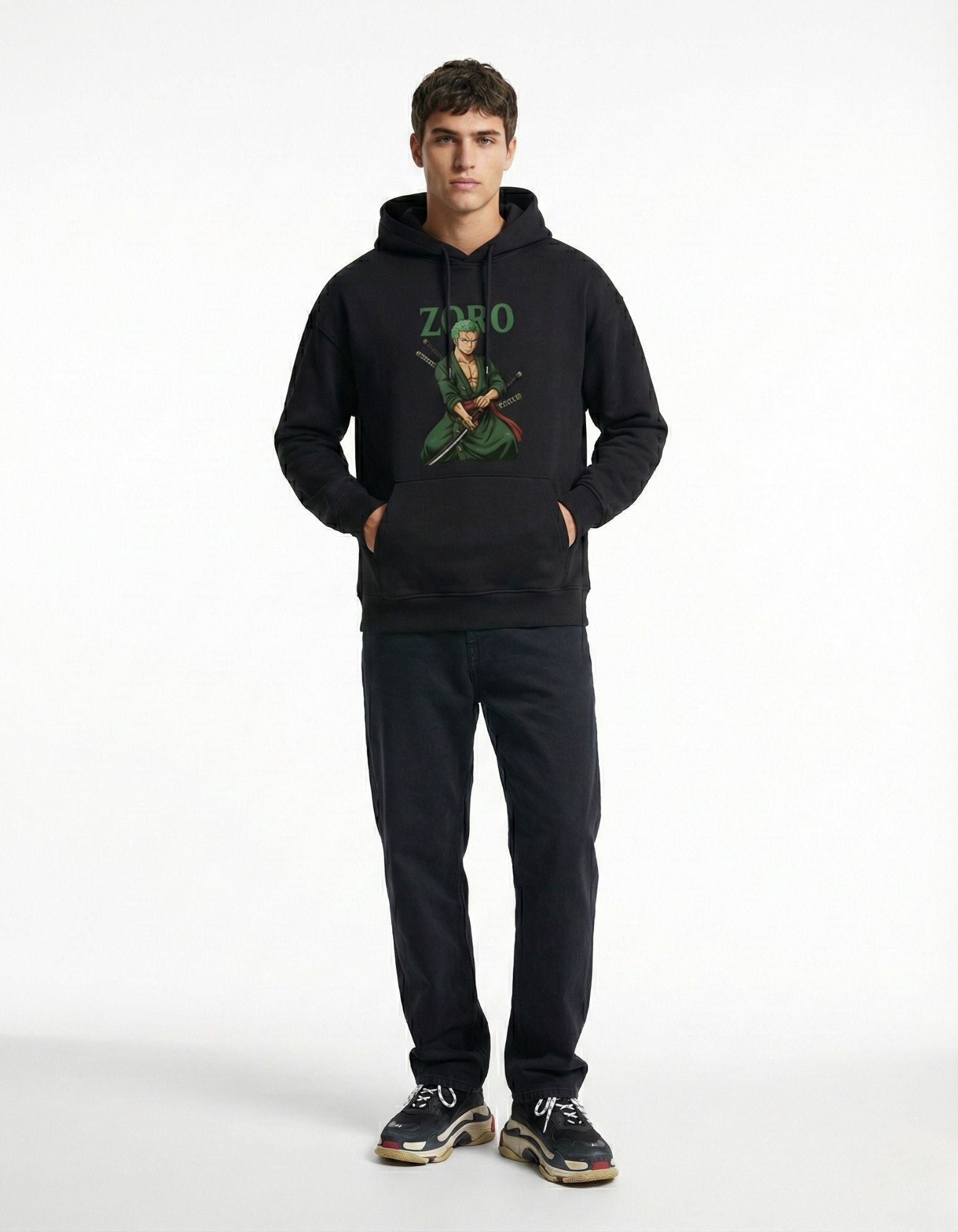 Male model posing with hands in the kangaroo pocket of a black Roronoa Zoro graphic hoodie, showcasing the detailed anime print.