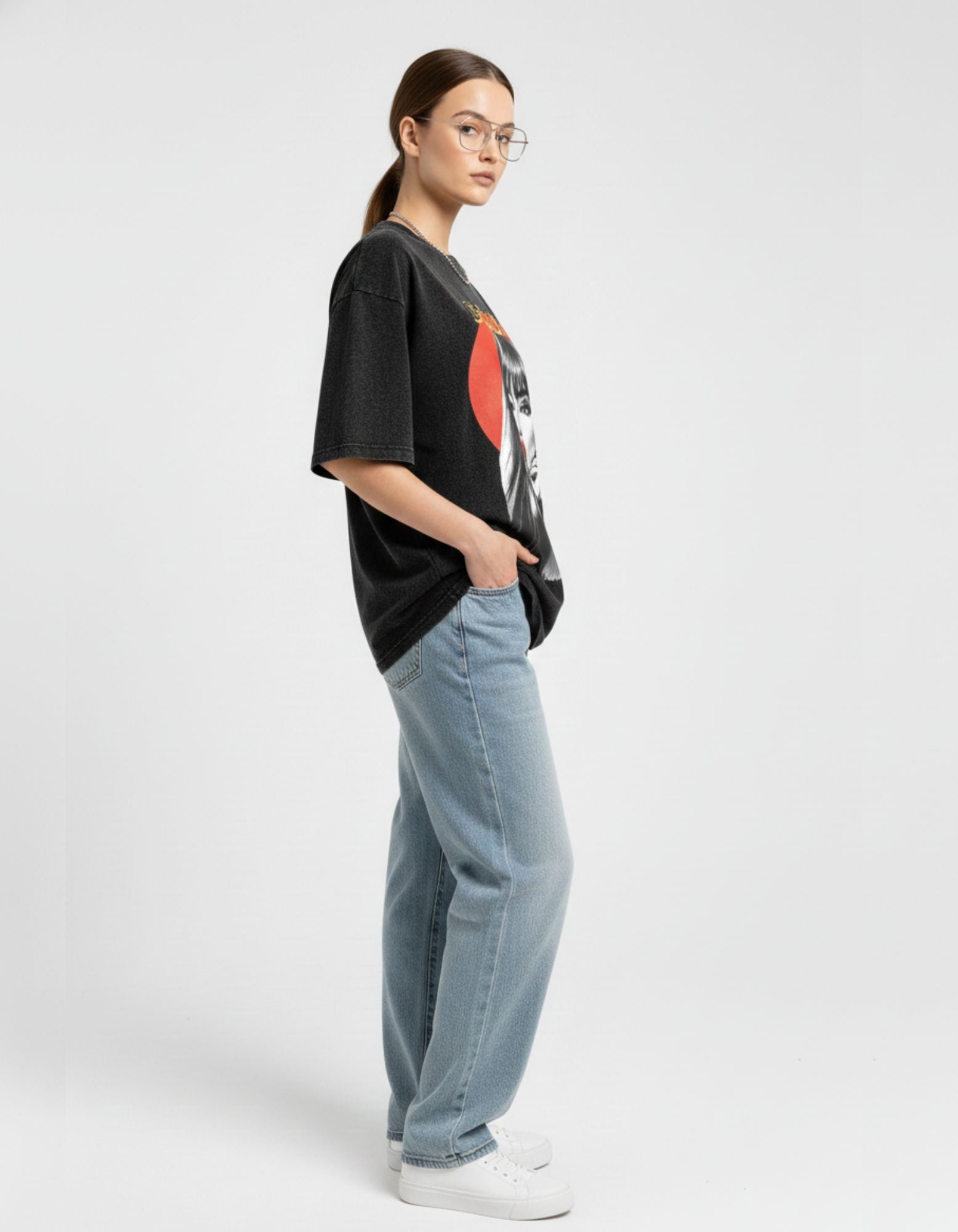 Side view of a charcoal vintage-wash oversized graphic tee paired with wide-leg denim for an urban look.