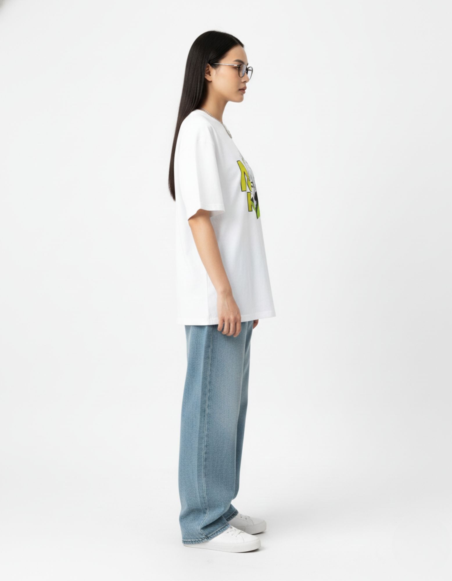"Side view profile of a model wearing an oversized anime streetwear tee and blue baggy jeans from GENZs Fashion."