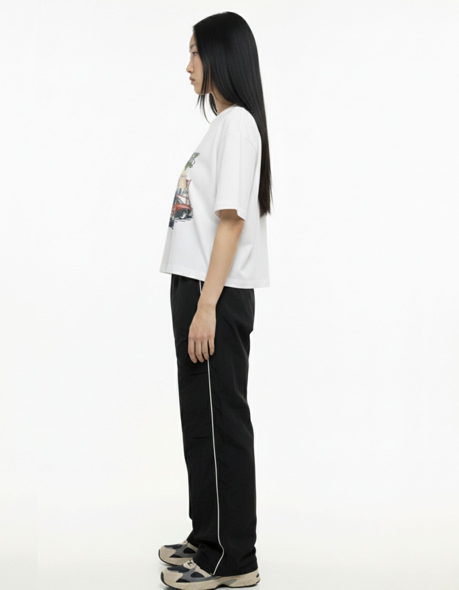 Side profile of woman in premium white oversized t-shirt showing drop shoulder fit.