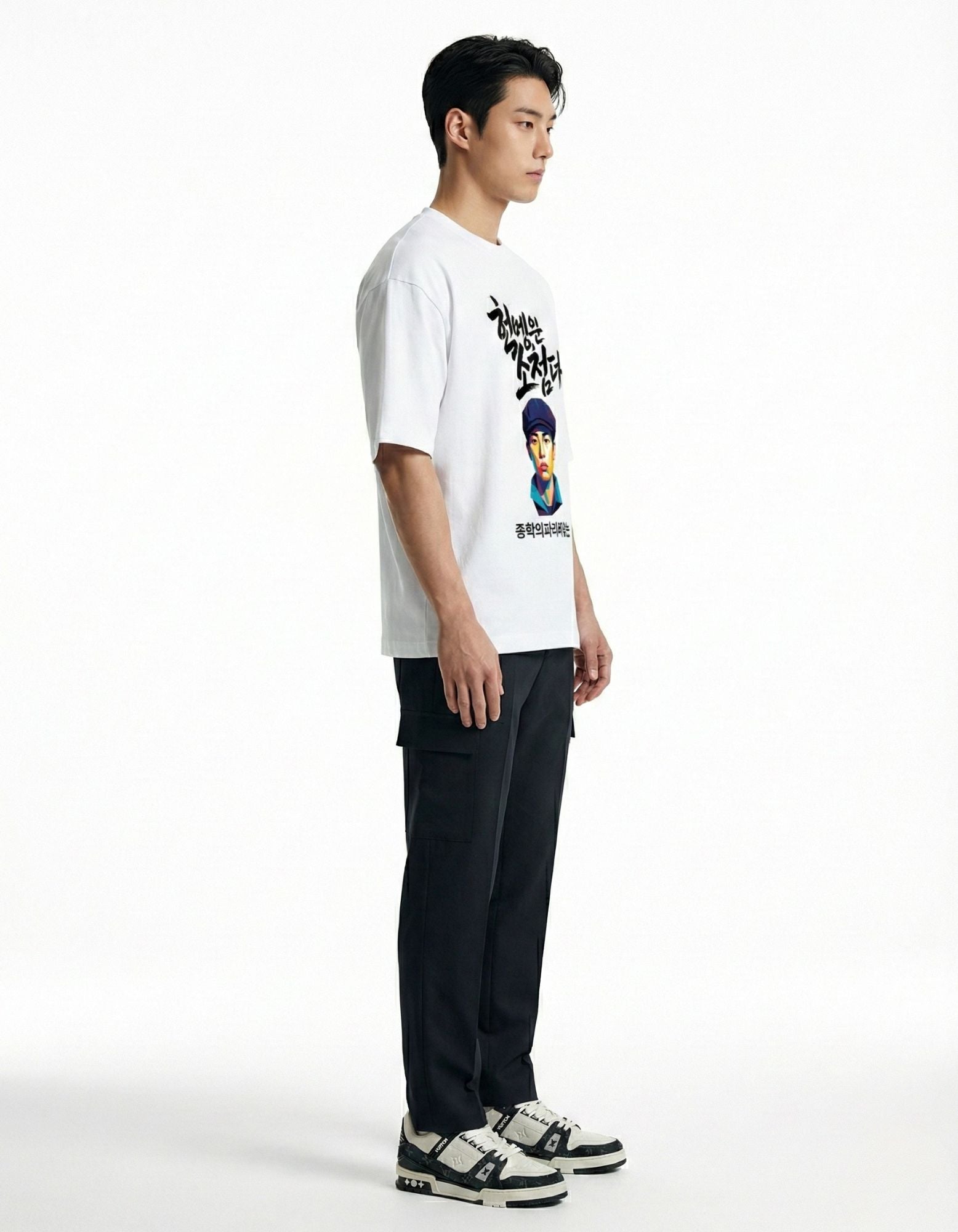 "Side profile of male model wearing a white oversized t-shirt, highlighting the loose drop shoulder fit."