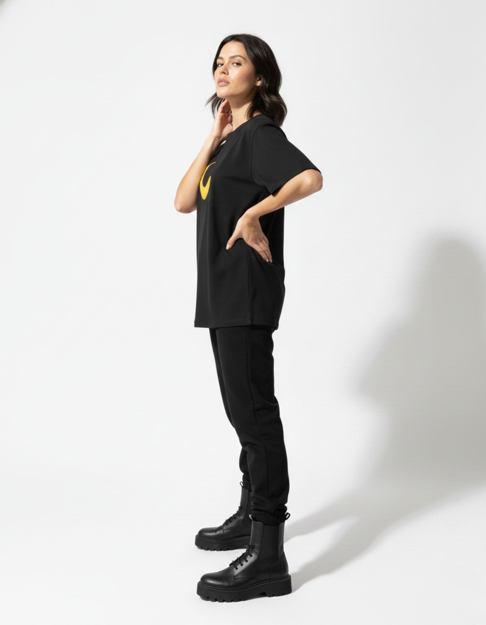Side profile of a GENZs Fashion oversized black graphic t-shirt showing the loose-fit streetwear aesthetic.