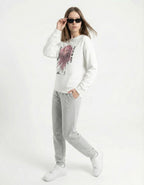 Female model posing in a white anime girl graphic sweatshirt and grey joggers, showcasing a 2025 soft-girl streetwear outfit.