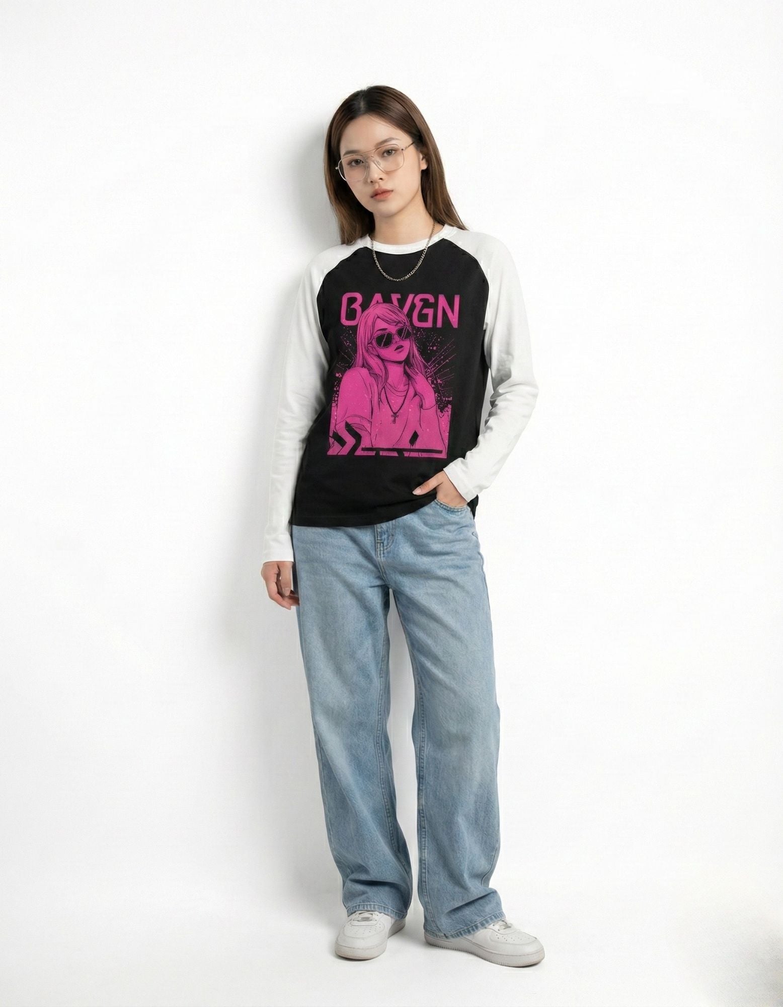 Front view of a women's black and white contrast sleeve shirt with a pink anime-style graphic and light denim.