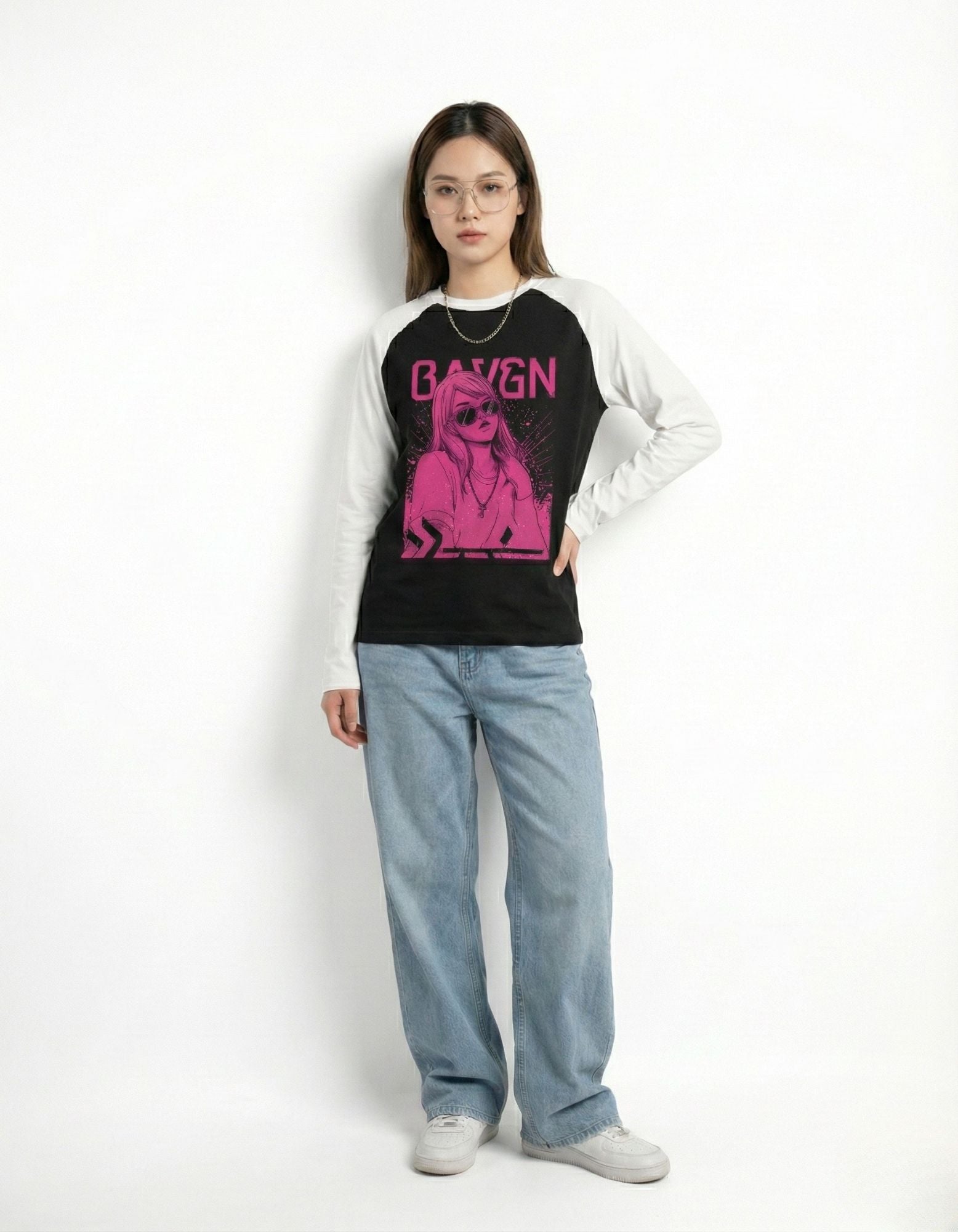 Front view of a women's black and white contrast sleeve shirt with a pink anime-style graphic and light denim.