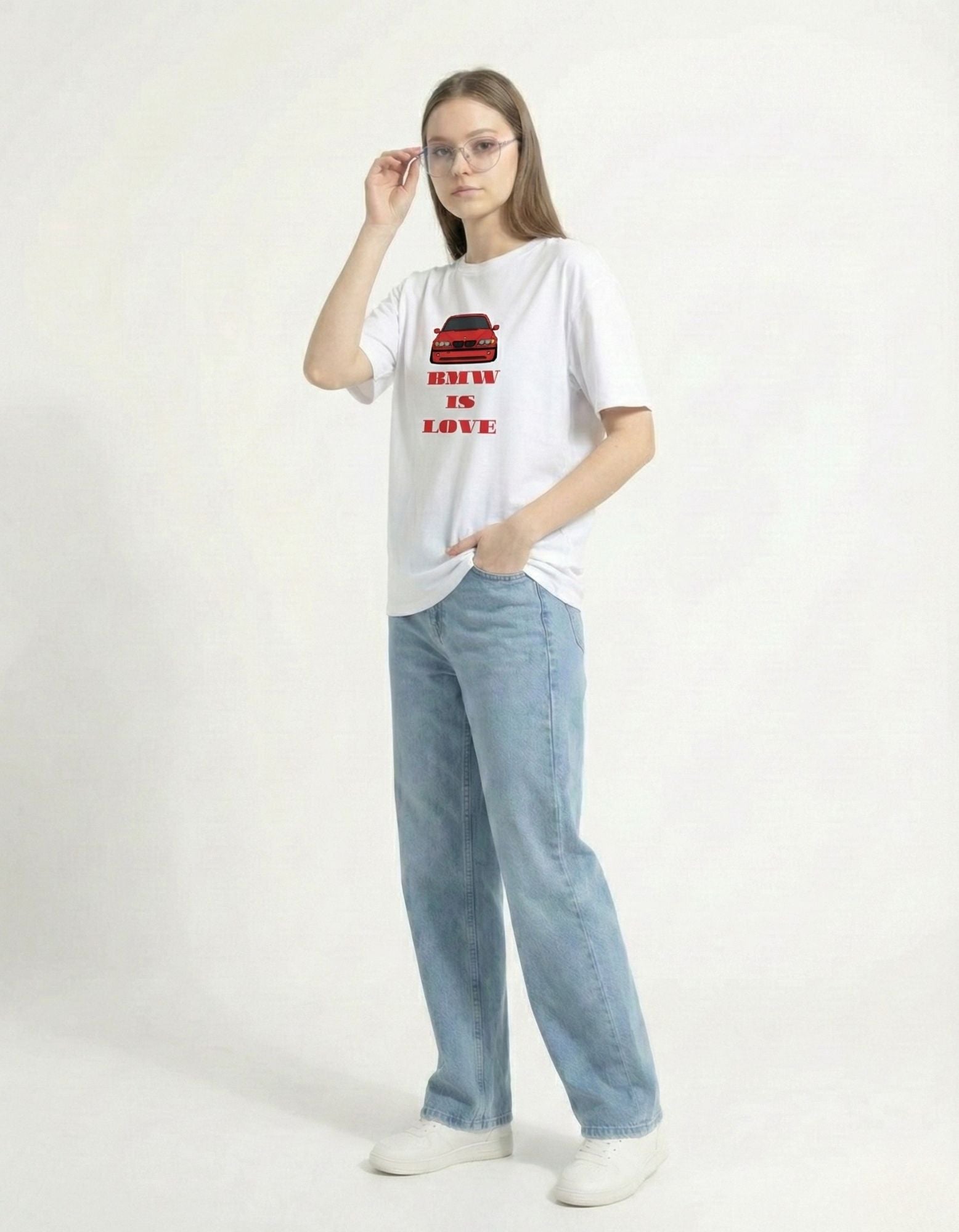 Female model posing with glasses in the white 'BMW IS LOVE' car tee, highlighting the trendy Gen Z brand aesthetic.