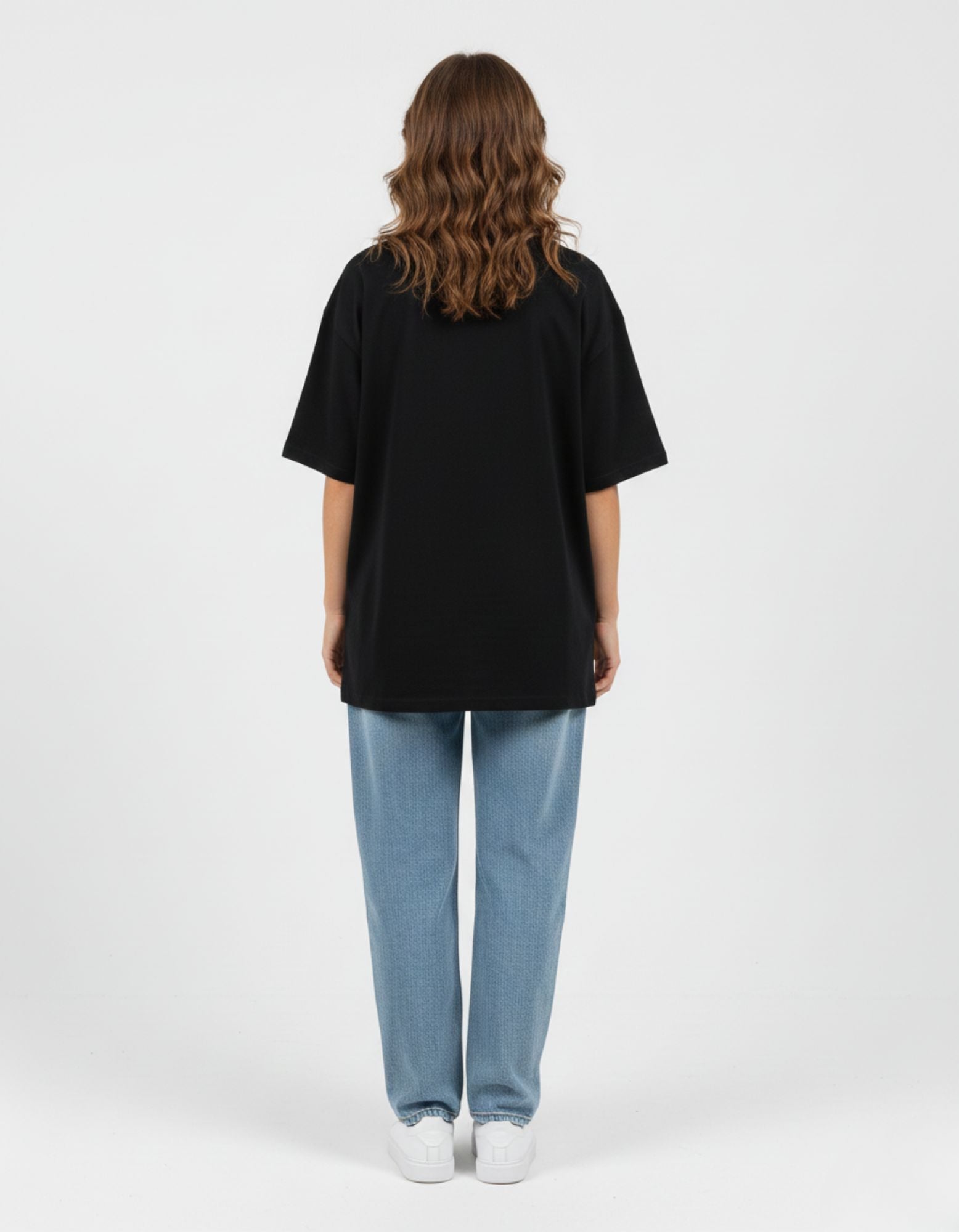 Back view of a unisex black oversized streetwear t-shirt showing the loose, comfortable drop-shoulder fit.