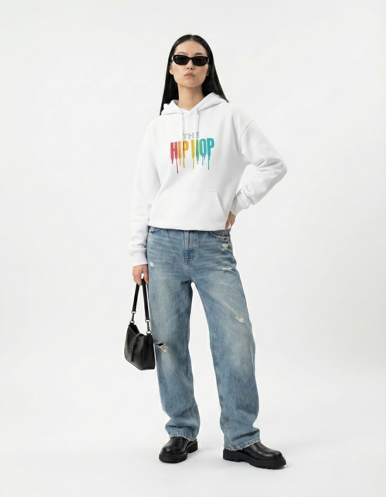 Female model wearing a GENZs Fashion white hip hop hoodie with baggy jeans and sunglasses for an urban aesthetic.