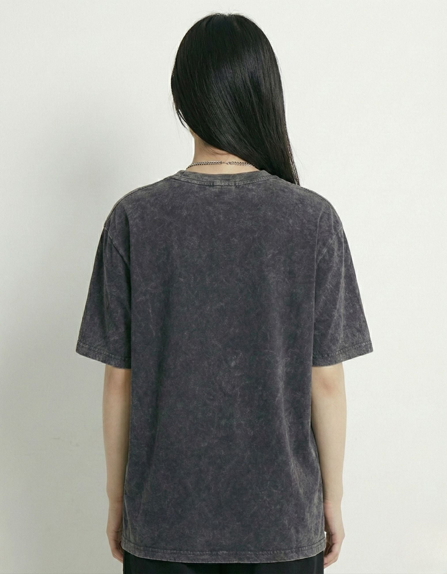 "Back profile of a charcoal vintage wash oversized streetwear t-shirt showing the relaxed fit and acid wash texture."