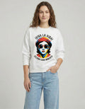 Female model standing in a white 'VIVA LA VIDA' sweatshirt featuring a vibrant, colorful pop-art face graphic.