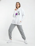 Female model wearing a white Among Us graphic hoodie with a purple character and 'He's Sus!' text, styled with gray joggers.