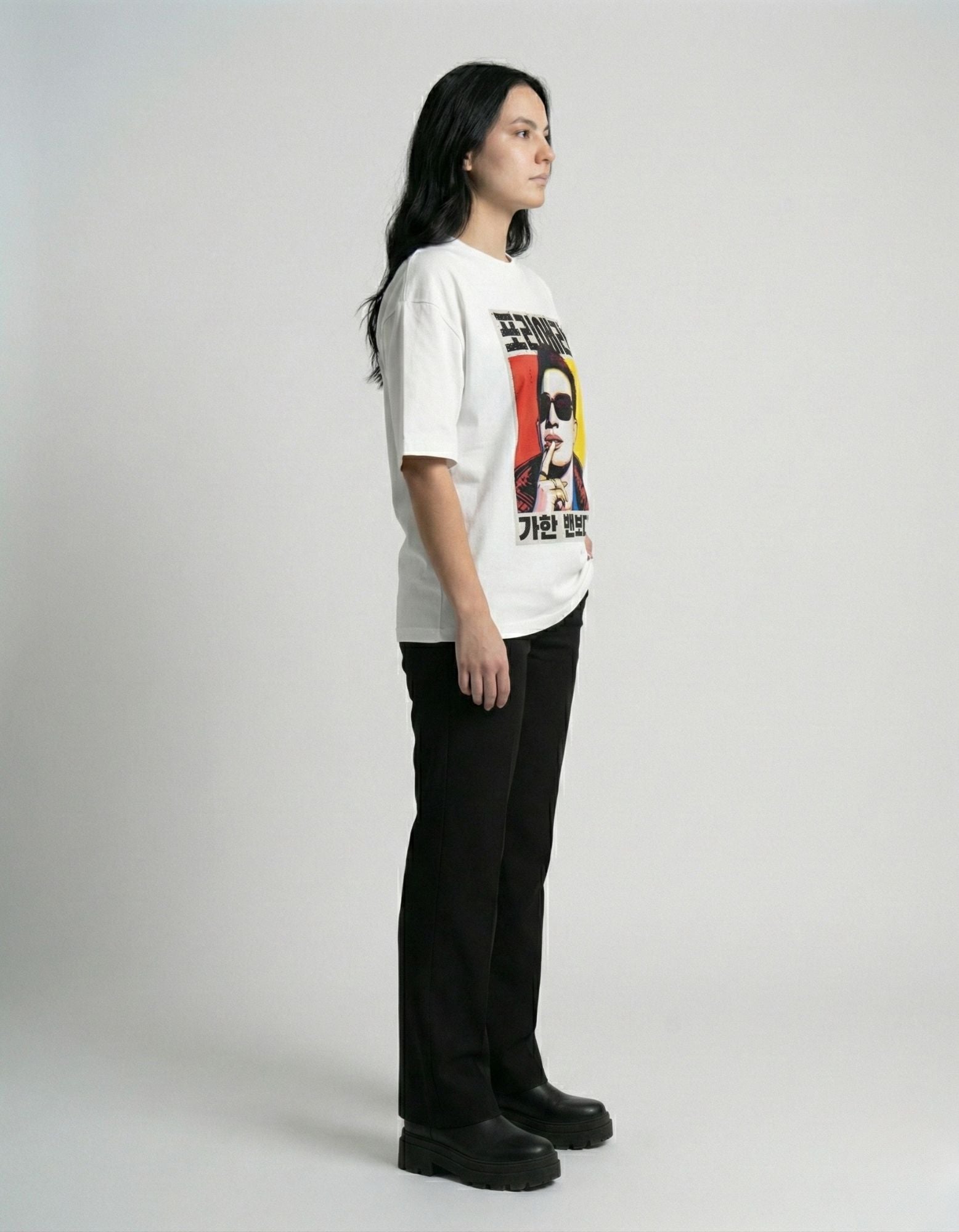 "Lifestyle shot of a woman wearing a white drop shoulder graphic tee with high-definition Korean print."