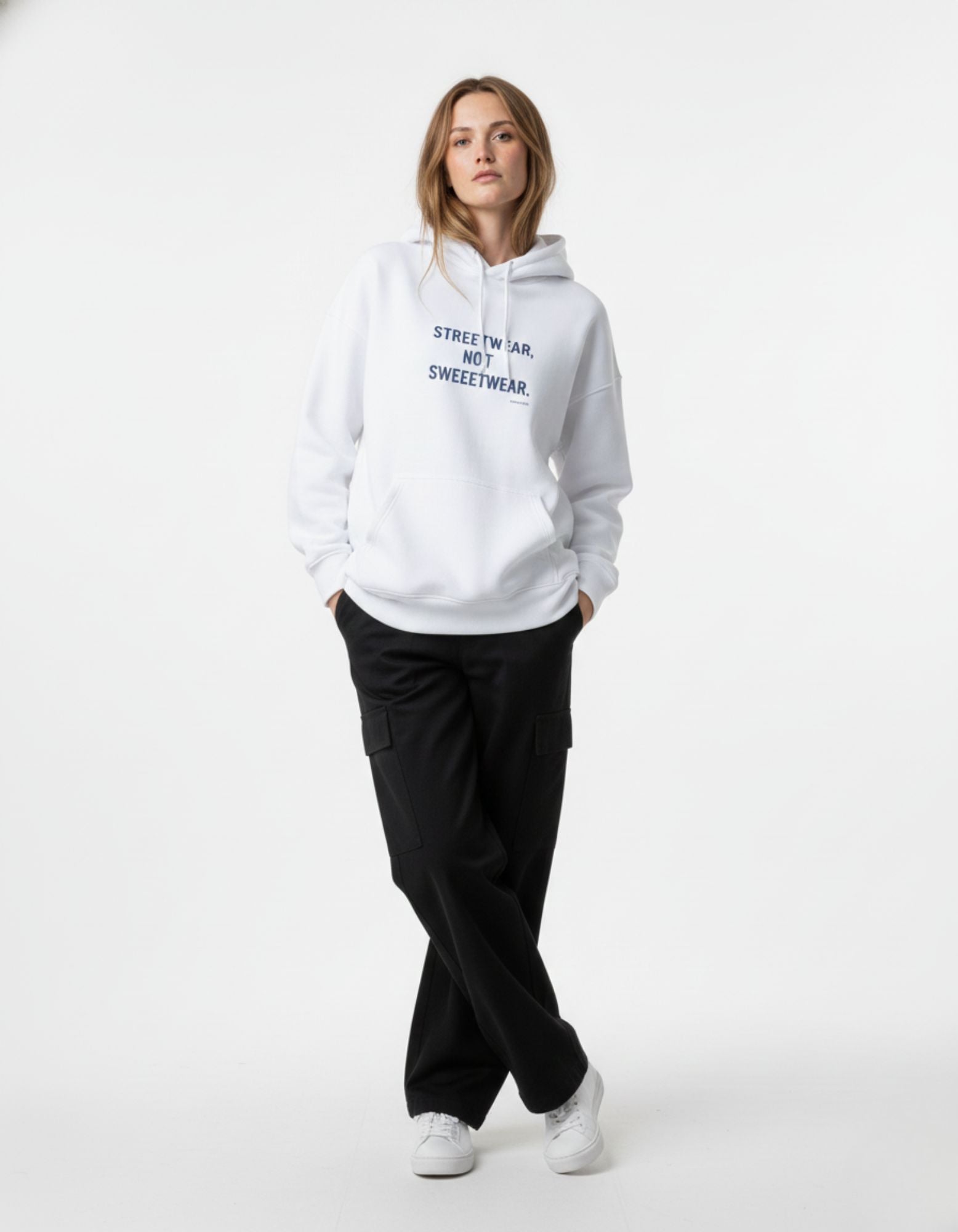 Female model standing in a white graphic hoodie, showing the relaxed fit and "STREETWEAR, NOT SWEETWEAR" text logo.