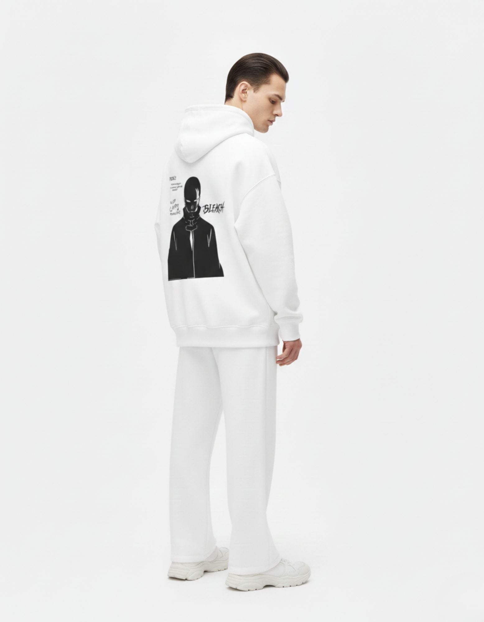 Male model showing the back graphic detail of a GENZs Fashion white oversized anime hoodie.
