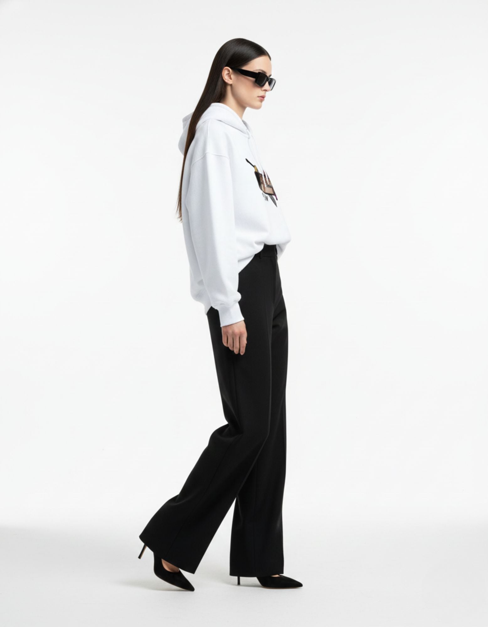 Side pose of white oversized hoodie worn by female model
