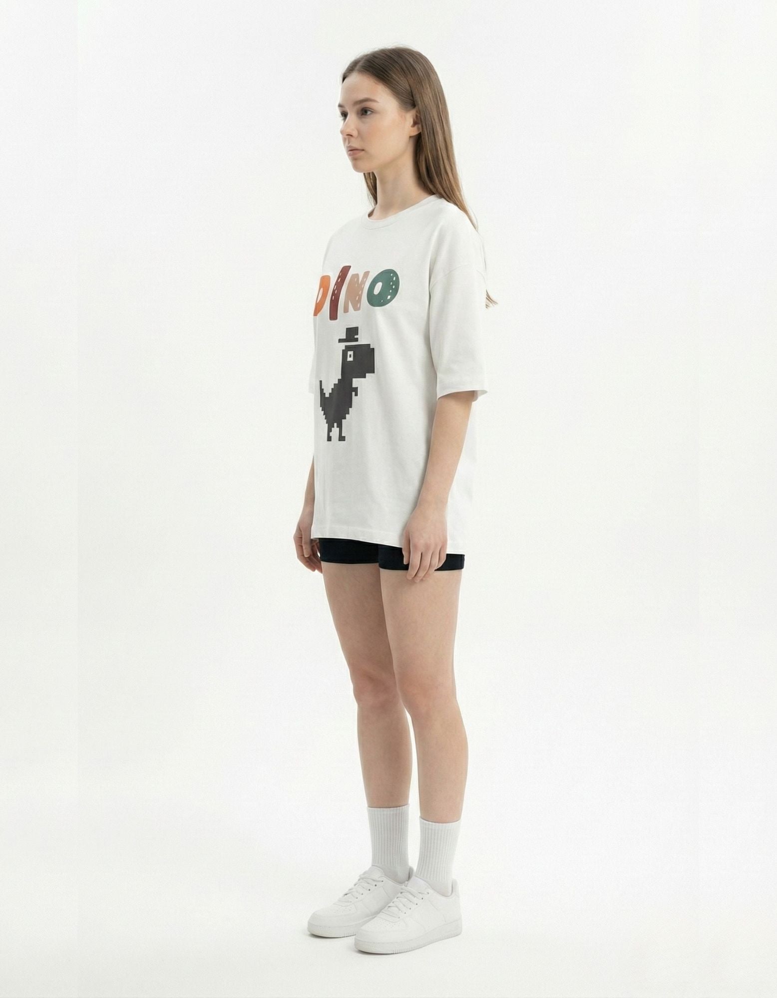 Side view of woman wearing white oversized pixel art t-shirt, high-quality drop shoulder streetwear in India.