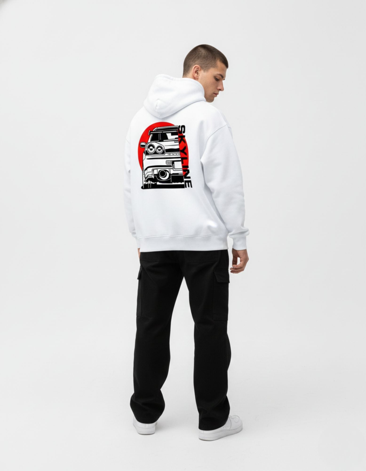 "Full-length shot of a white Skyline car graphic hoodie styled with black cargo pants for a modern JDM streetwear look."