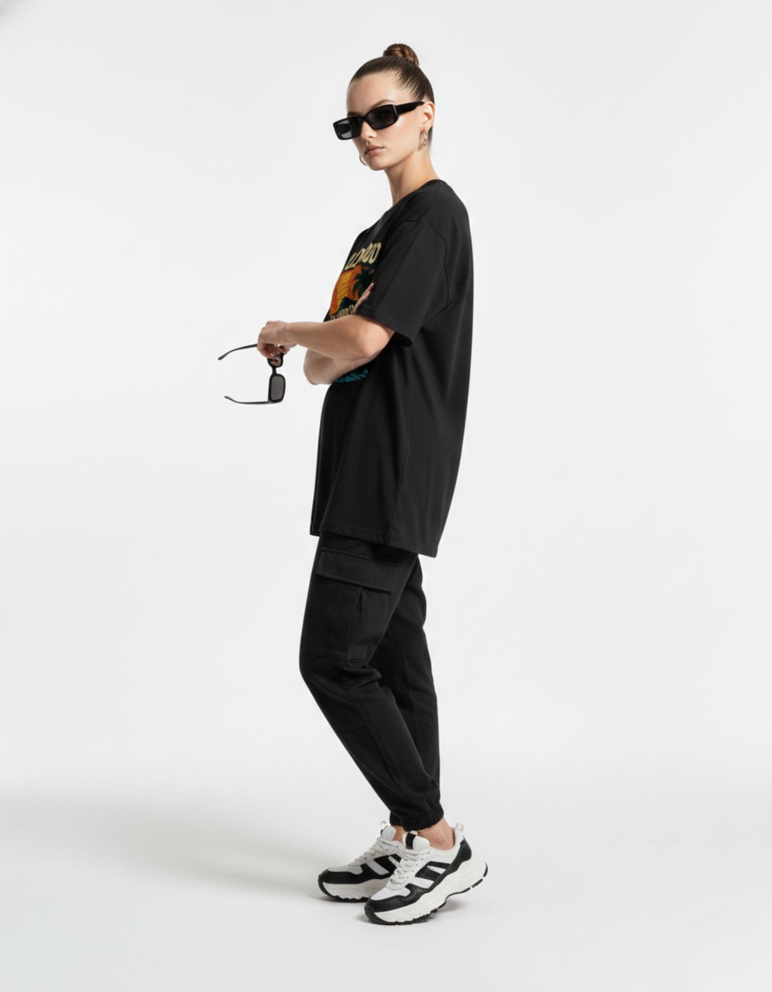 Side profile of man in black boxy fit graphic t-shirt, trendy streetwear apparel.