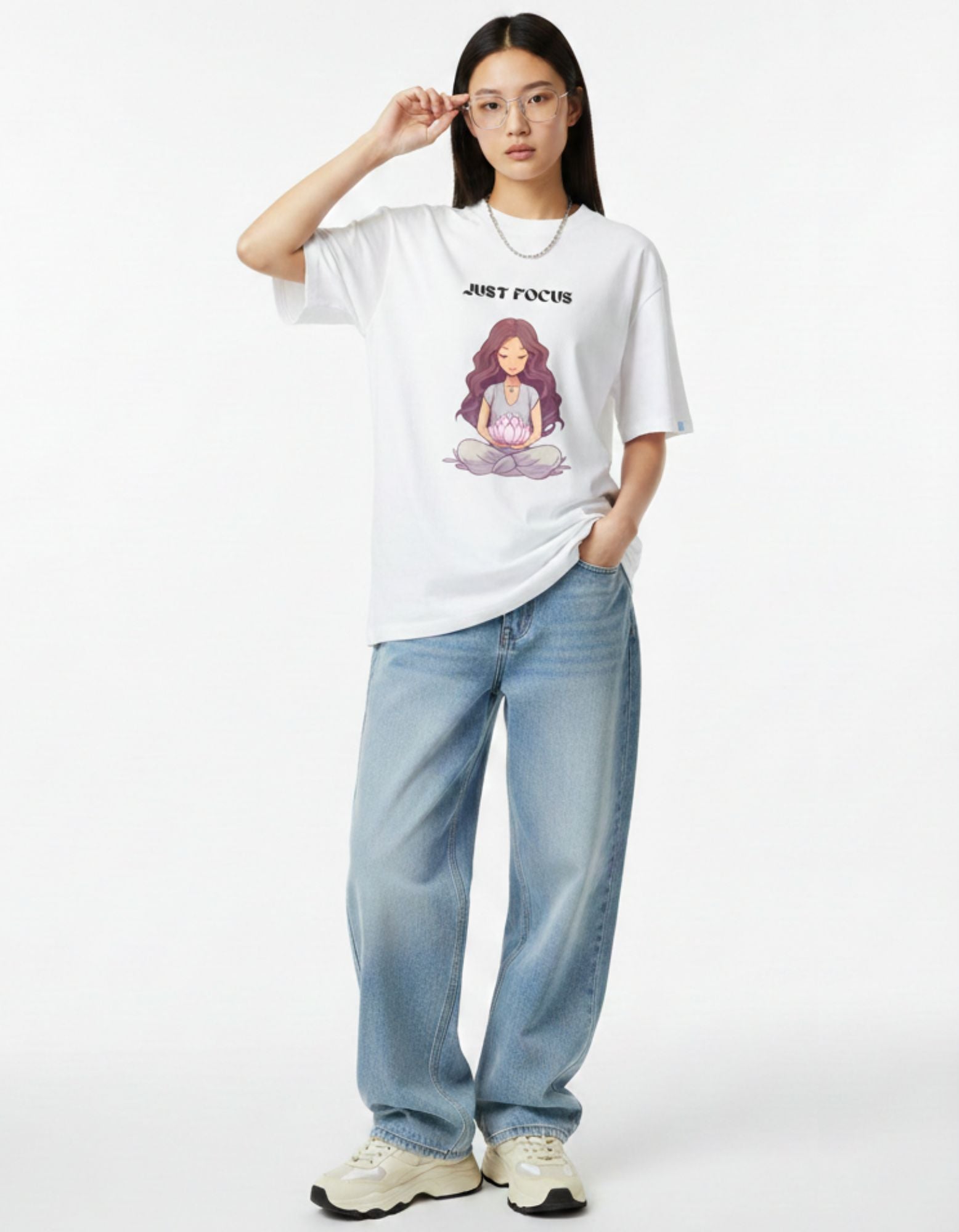 Woman in a thoughtful pose wearing white oversized meditation graphic tee, spiritual streetwear India.