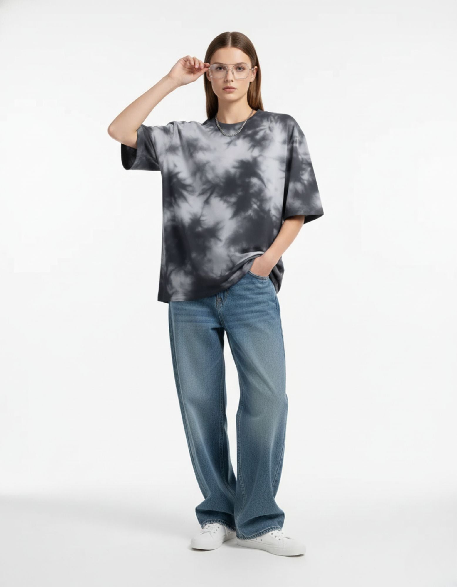 "Female model wearing a gray and black oversized tie-dye t-shirt, stylish and comfortable unisex streetwear."