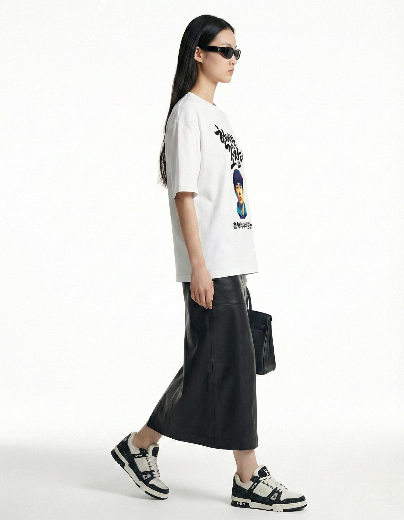 "Side view of a woman in a white oversized graphic tee, paired with a modern long black skirt."