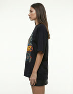 Side profile of a woman wearing a black vintage horror-themed graphic tee from GENZs Fashion, highlighting the relaxed drop-shoulder streetwear fit.