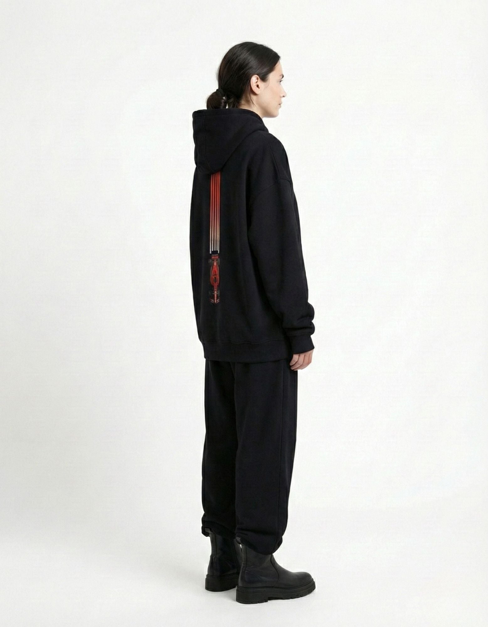 Side profile of female model in a black GENZs Fashion racing-themed hoodie, perfect for an F1 weekend aesthetic.