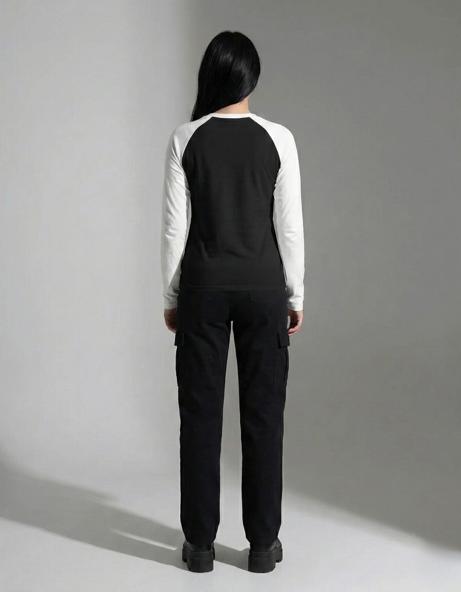 Back view of a black and white baseball-style long-sleeve shirt showing the fit and contrast sleeve design.