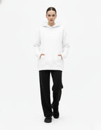 Front view of a female model in a comfortable white oversized hoodie, perfect for Gen Z streetwear fashion.