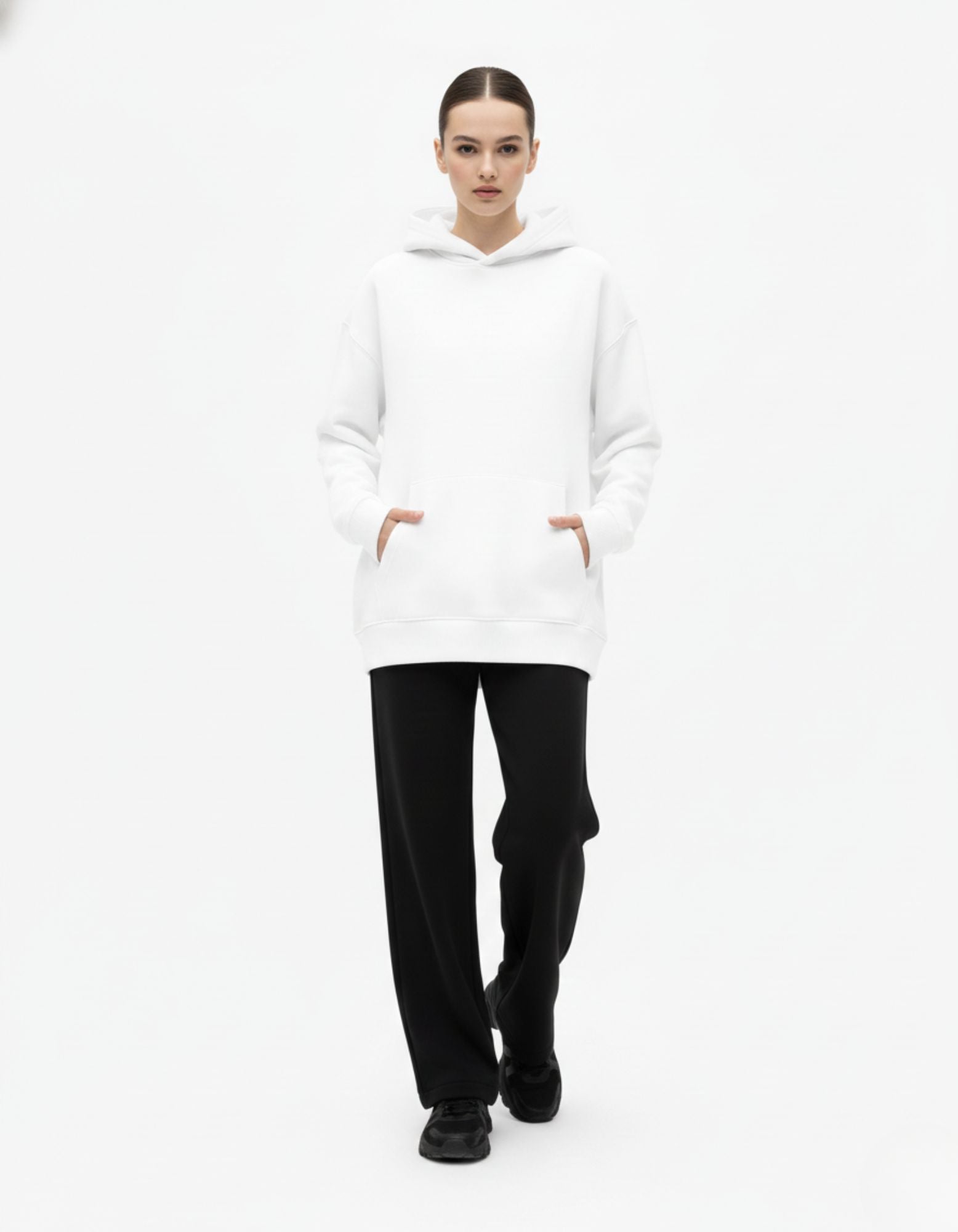 Front view of a female model in a comfortable white oversized hoodie, perfect for Gen Z streetwear fashion.