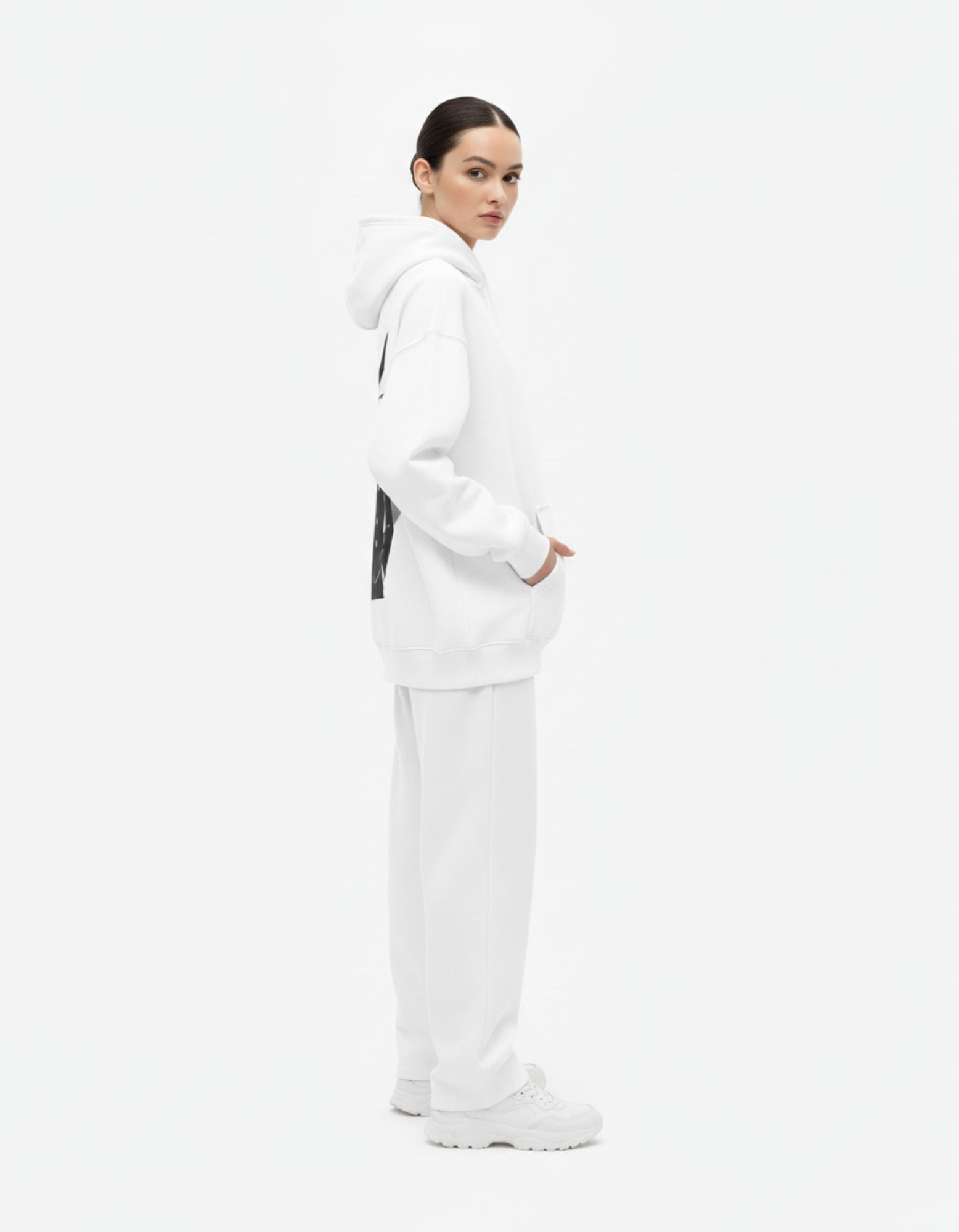 Side view of female model wearing white Mob Psycho 100 graphic hoodie, oversized streetwear fit.