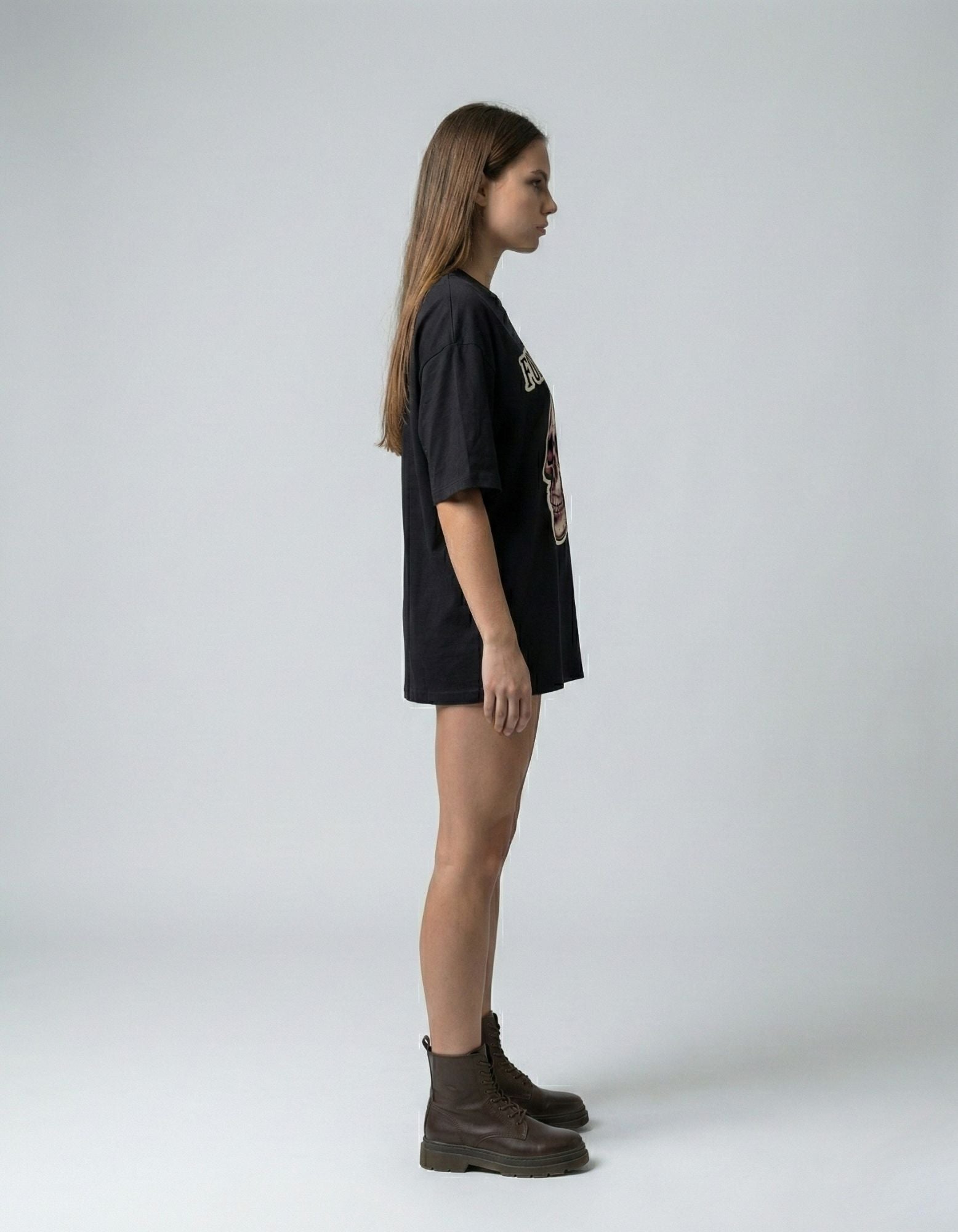 Side profile of a woman in a black oversized graphic streetwear t-shirt from GENZs Fashion.