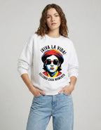 Front view of a female model wearing a white art-inspired sweatshirt with hands in her denim pockets for a casual look.