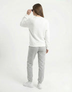 Side view of a female model wearing an oversized white anime sweatshirt with black sunglasses for a trendy urban look.