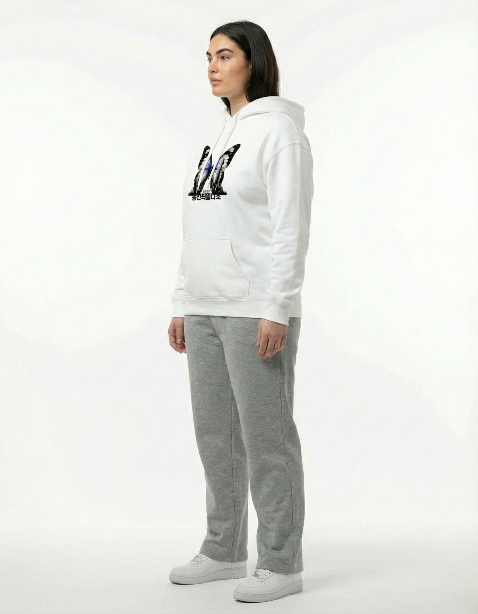 Side view of female model wearing a heavyweight white cotton hoodie with butterfly print, premium streetwear fit.